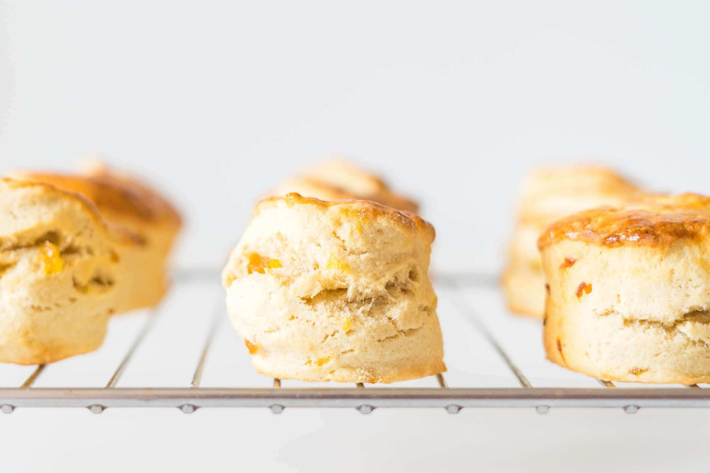 Freshly baked Meyer lemon lavender scones cooling on a wire rack, golden and fluffy.