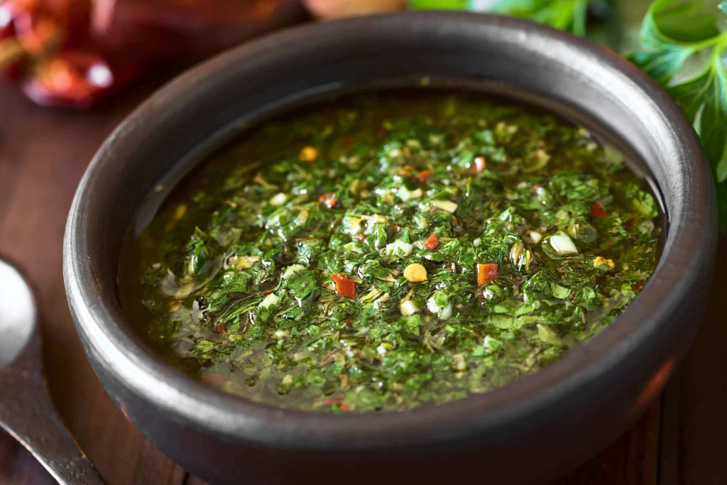 Bowl of vibrant green salsa with herbs and spices, perfect for enhancing your culinary dishes.