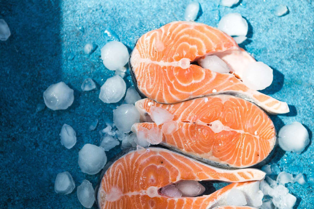 Fresh salmon fillets on ice, showcasing vibrant orange flesh and marbling, ideal for gourmet recipes.