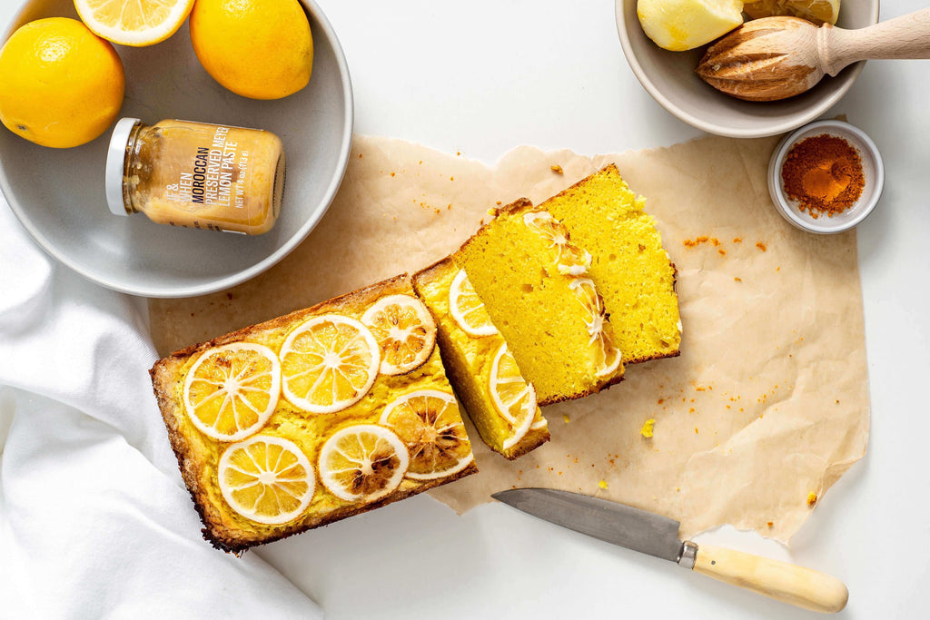 Freshly baked turmeric lemon cake garnished with sliced lemons and served with preserved lemon paste.